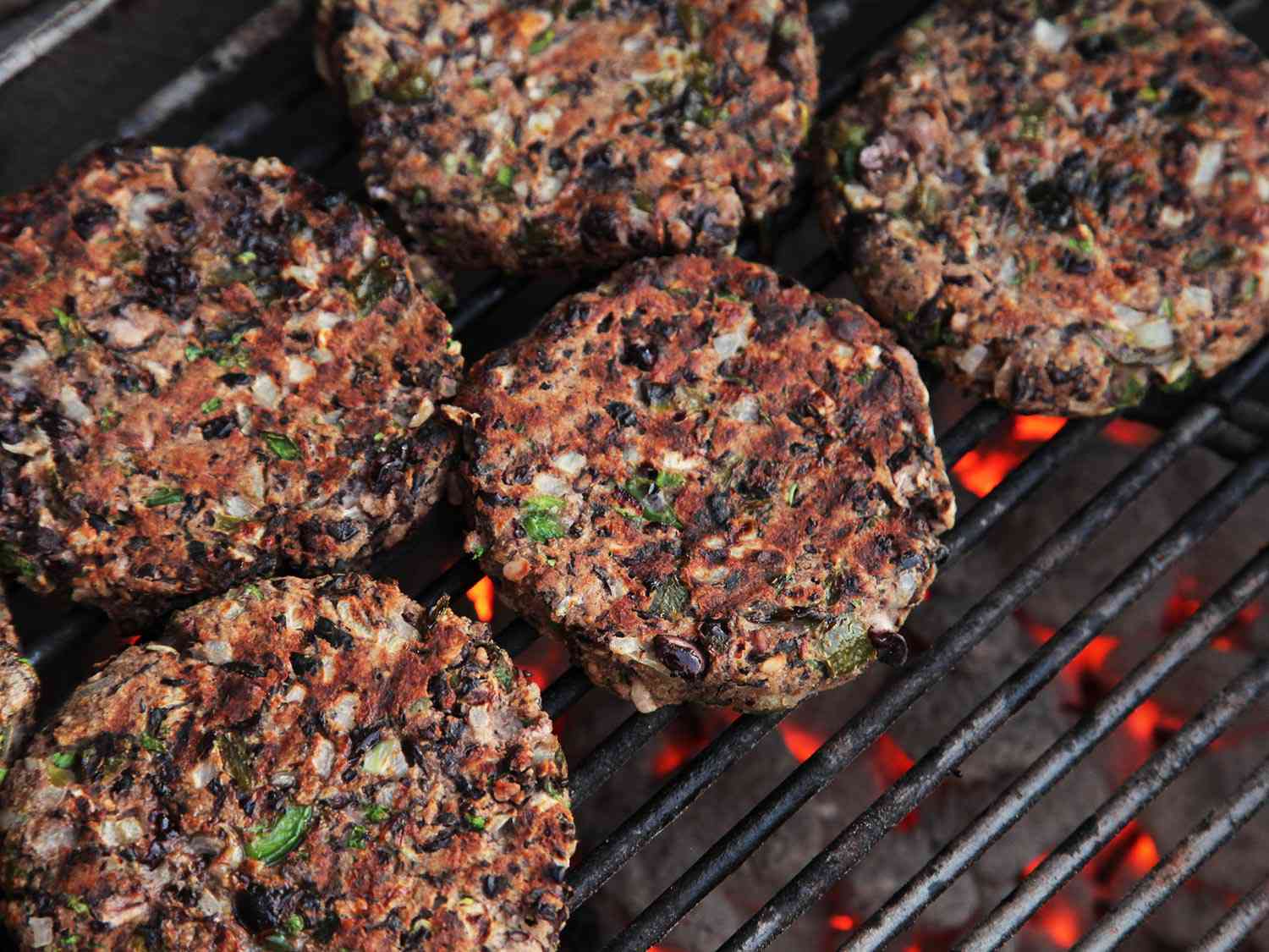 Panko vegetarian burger patties grilling on a barbecue.