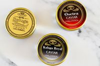 a collection of Olma caviar jars: Beluga hybrid caviar, osetra caviar, and kaluga royal caviar