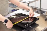 The iSiLER portable induction cooktop being measured with retractable measuring tape.