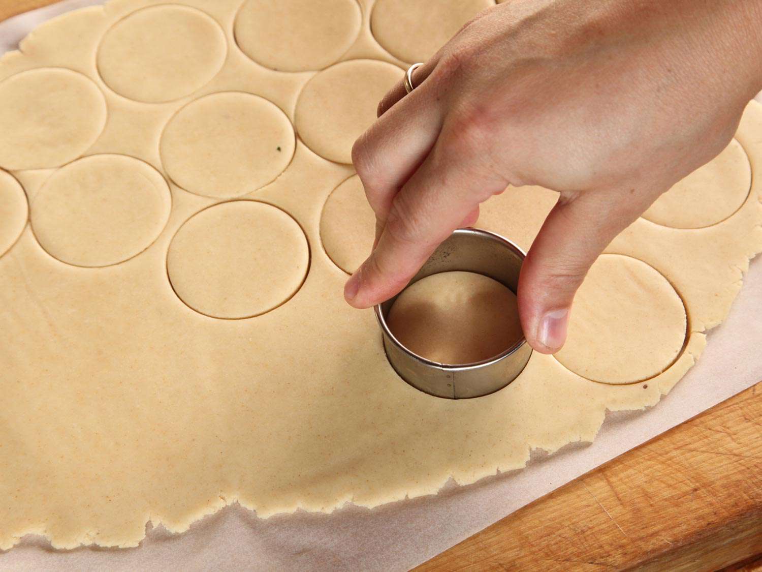 Punching out disks of shortbread dough from a thin sheet of dough. 