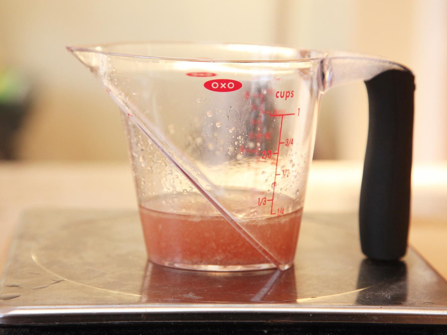 Liquid measuring cup of liquid expressed from chicken breast cooked sous vide to 150 degrees Fahrenheit.