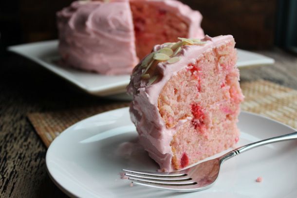 slice of pink cake with cherries
