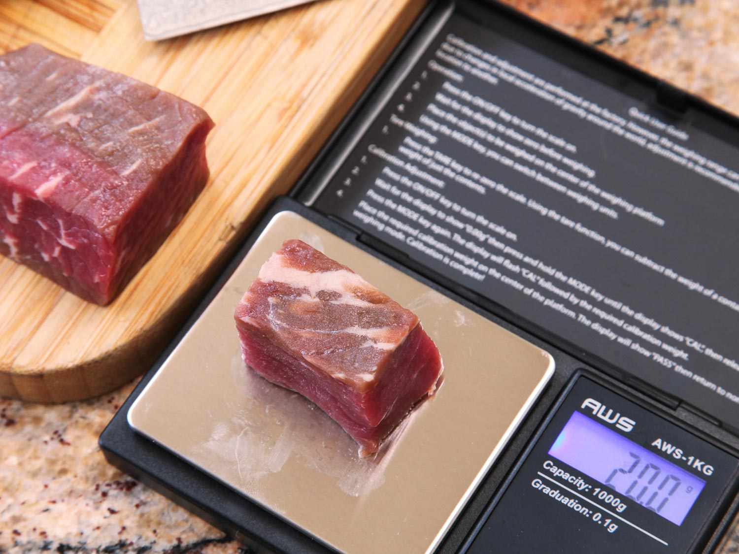 A raw cube of beef is weighed on a precision scale.