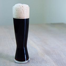 A tall, super-dark (almost black) pint glass of schwarzbier.