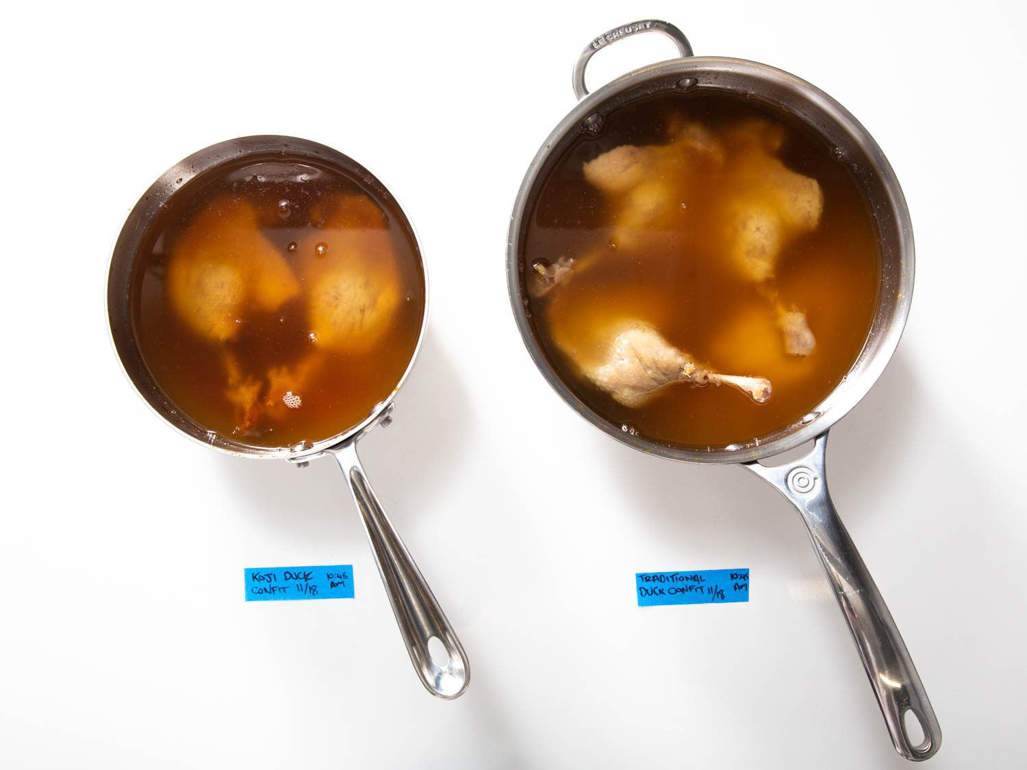Overhead of saucepans with traditional and koji duck confit.