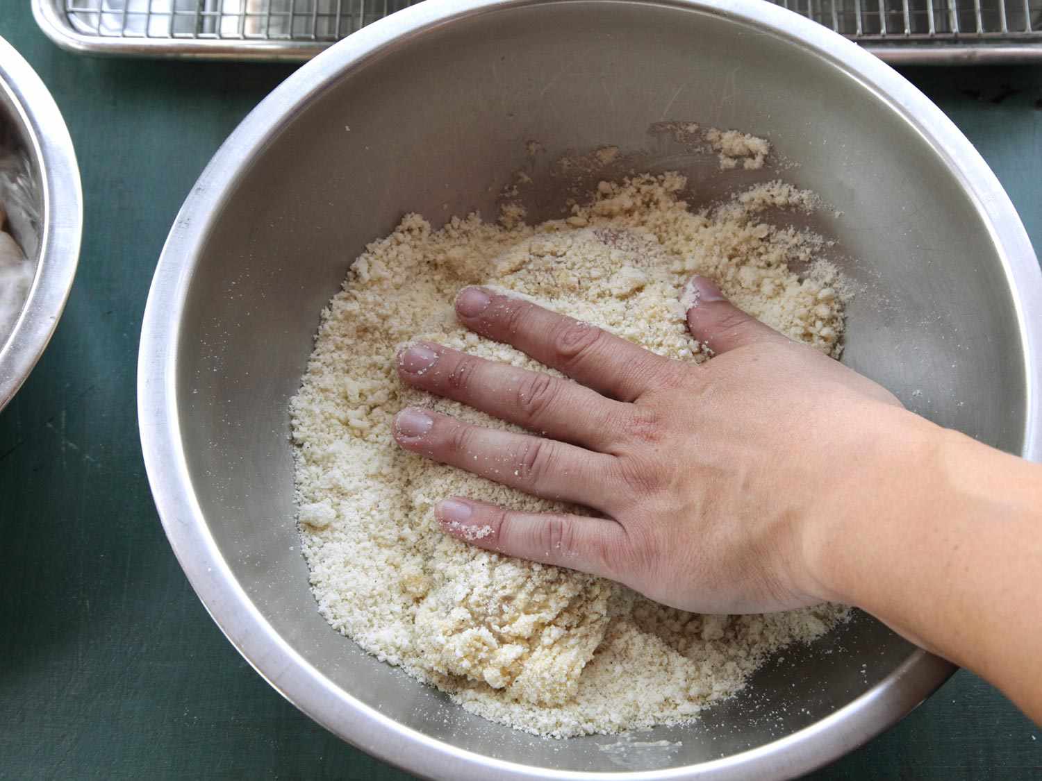 Coating egg-dipped chicken breast into bread crumbs