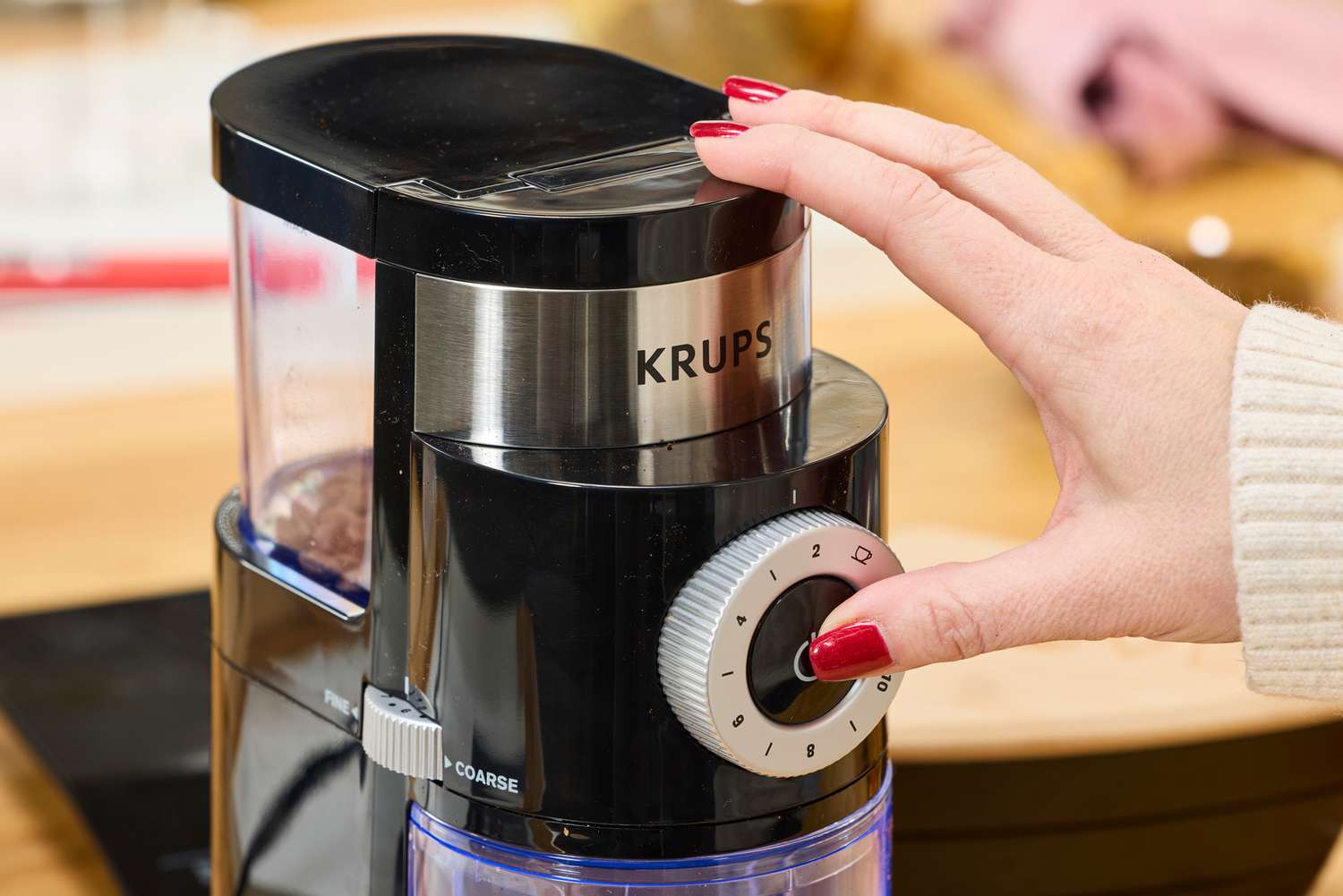 Person pressing button on Krups Precision Coffee Grinder