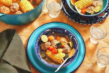 Overhead view of Mexican Albondigas in a bowl with pot and water