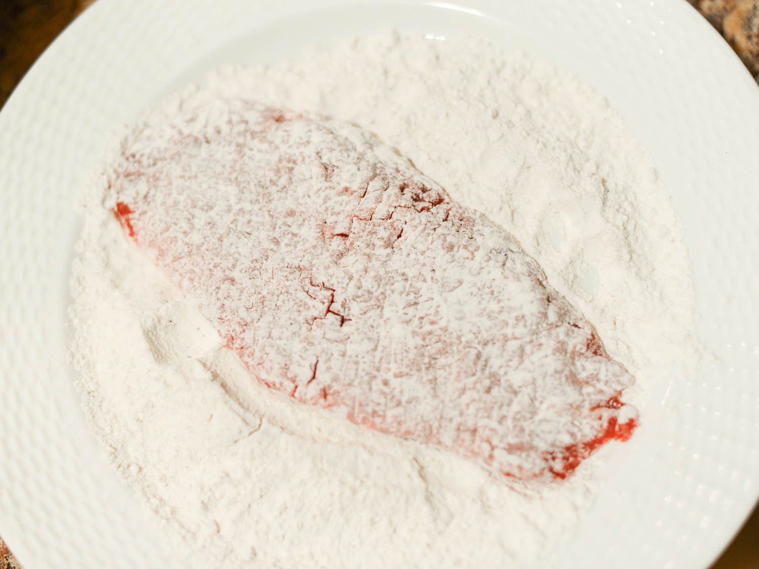Dredging steak in flour.