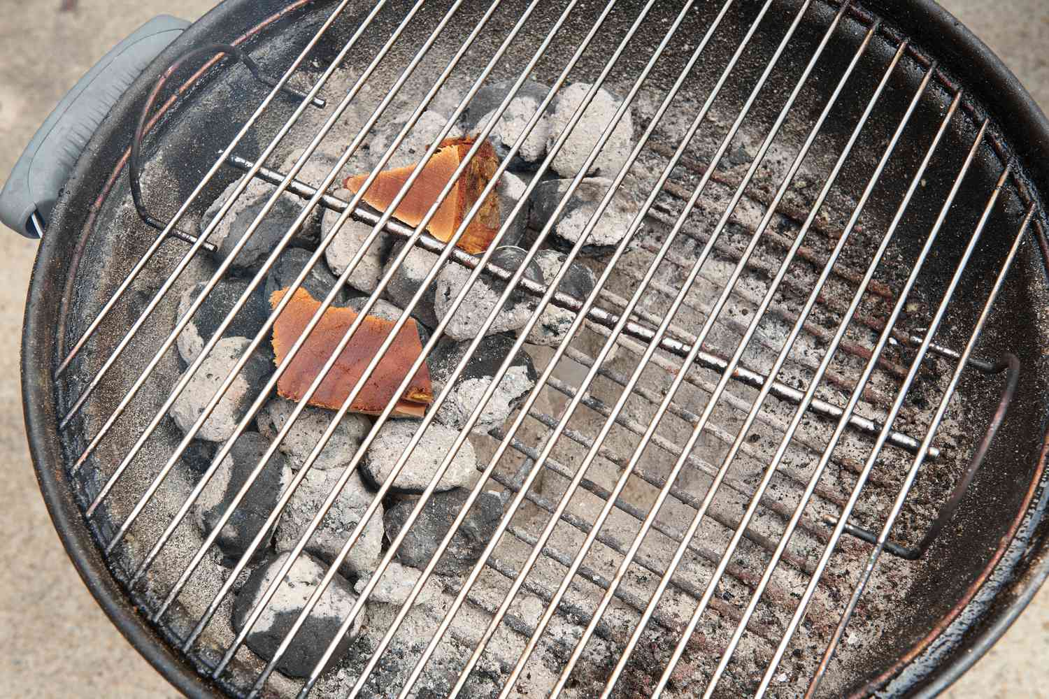 Gray-ash covered coals spread out evenly over half of coal grate creating a two-zone indirect fire