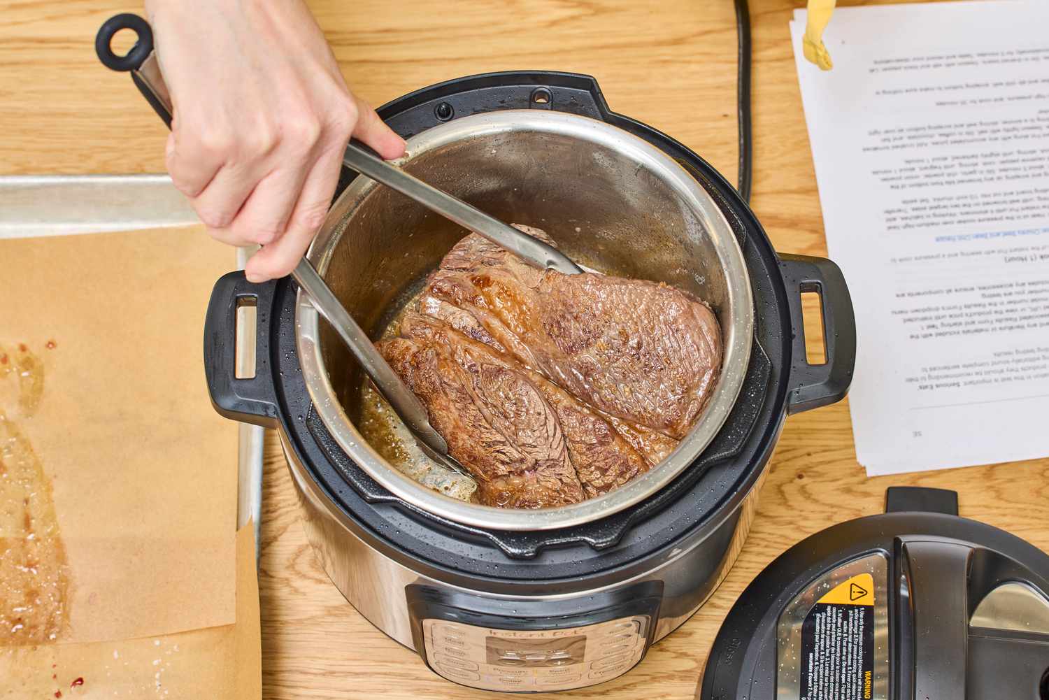 A person cooks meat in the Instant Pot Pro 10-in-1 6-Quart Pressure Cooker