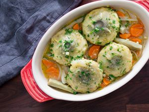 Overhead view of Artichokes à la Barigoule, served in a enalemed oval casserole dish.