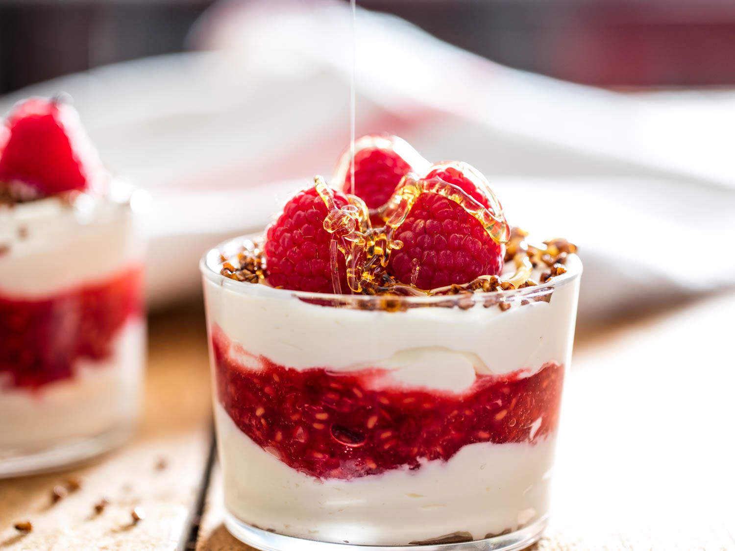 Drizzling honey on a glass of cranachan.
