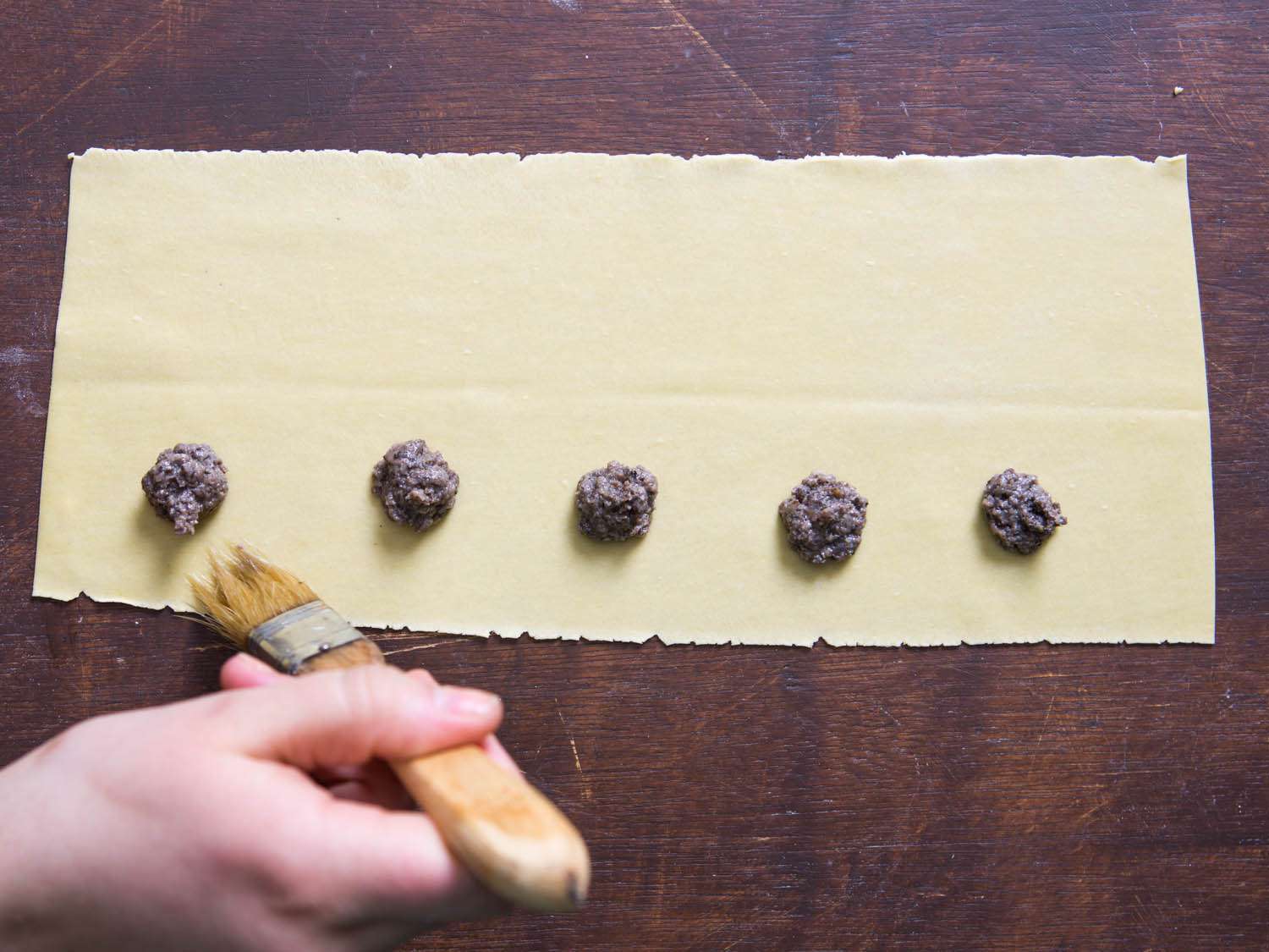 The edges of the pasta are brushed with water. 