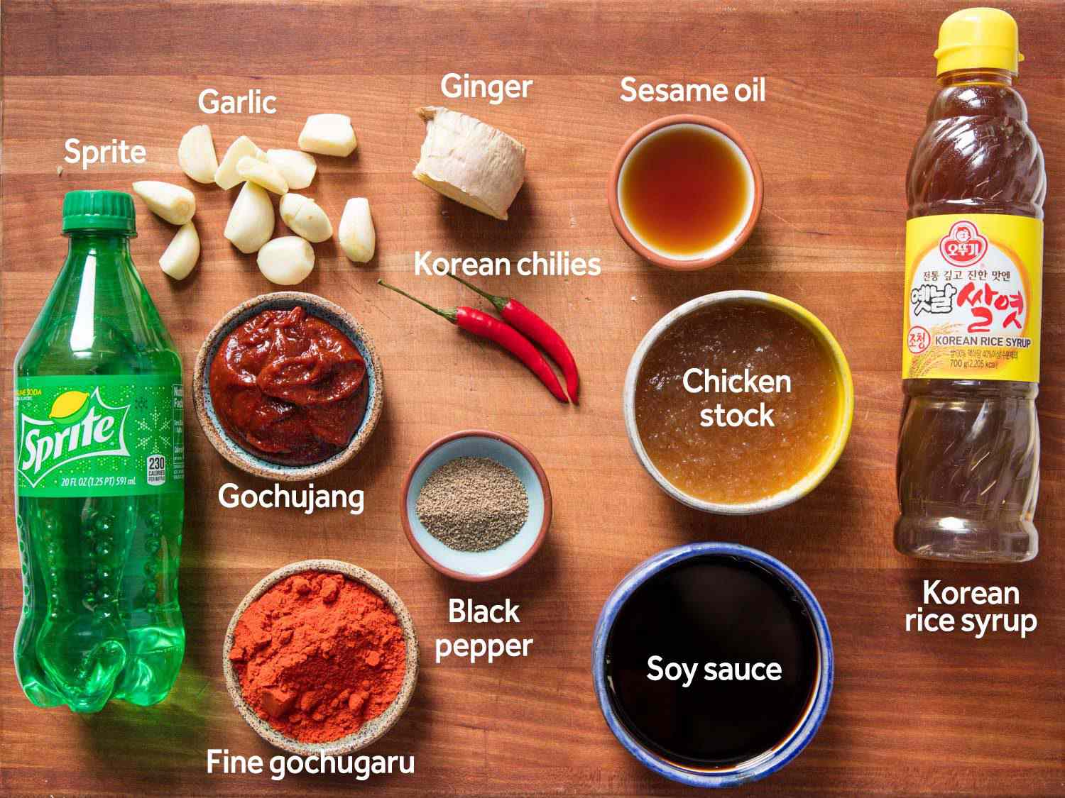 Ingredients for Korean buldak sauce: garlic, ginger, sesame oil, Korean rice syrup, soy sauce, chicken stock, black pepper, fine gochugaru, gochujang, Korean chiles, and Sprite
