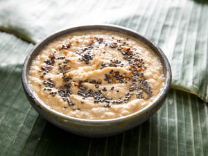 A bowl of coconut chutney served on a surface covered with a banana leaf.