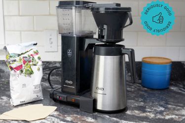 the technivorm moccamaster on a countertop with a bag of coffee and some filters