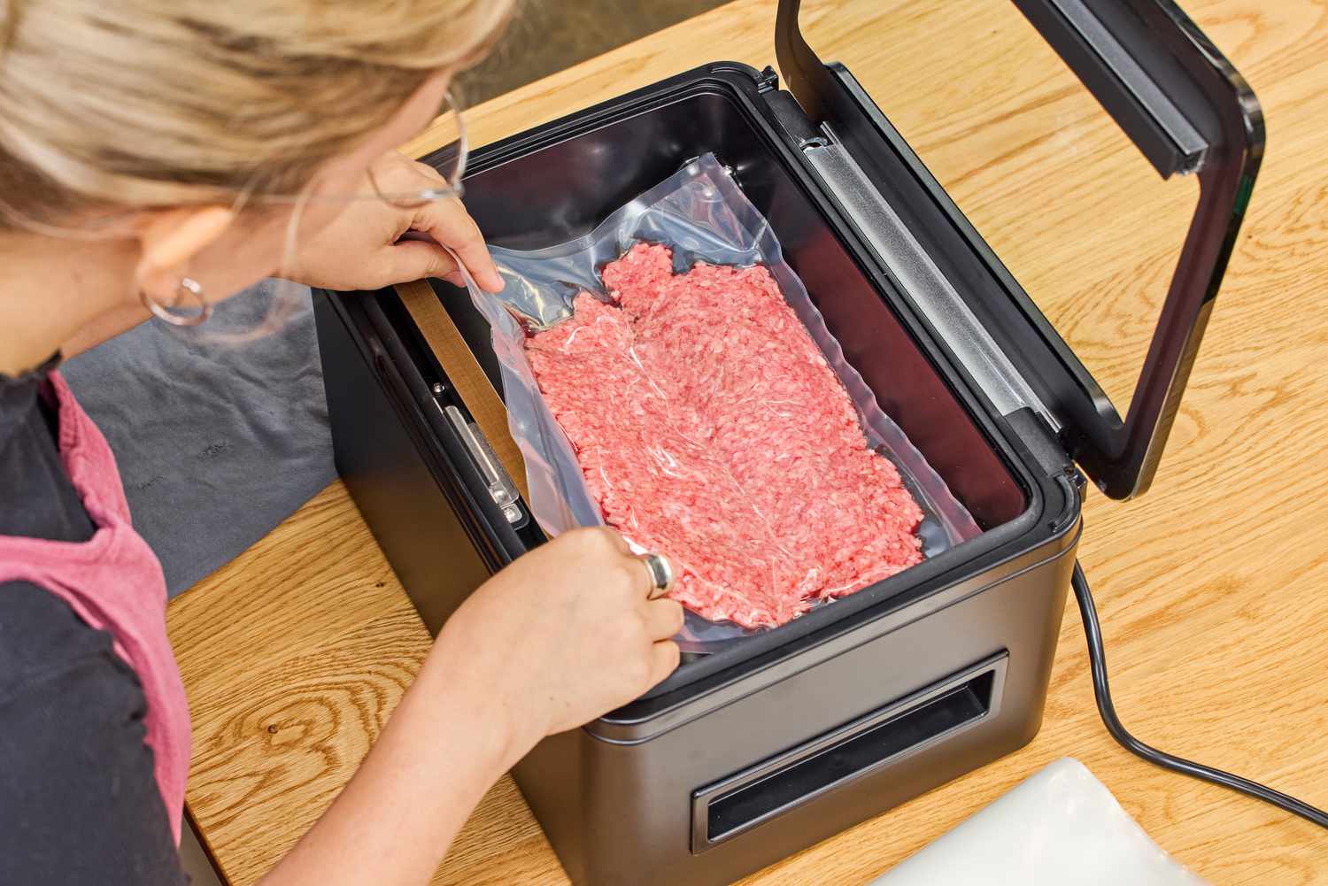 A bag of ground meat is vacuum sealed using the Anova Precision Chamber Vacuum Sealer