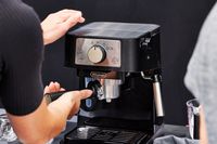 Hands adjusting the portafilter on the De'Longhi Stilosa Espresso Machine