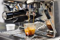 The Breville Barista Express Impress brewing an espresso into a glass 