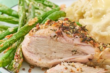 Plate of herbed chicken drumsticks green beans and mashed potatoes