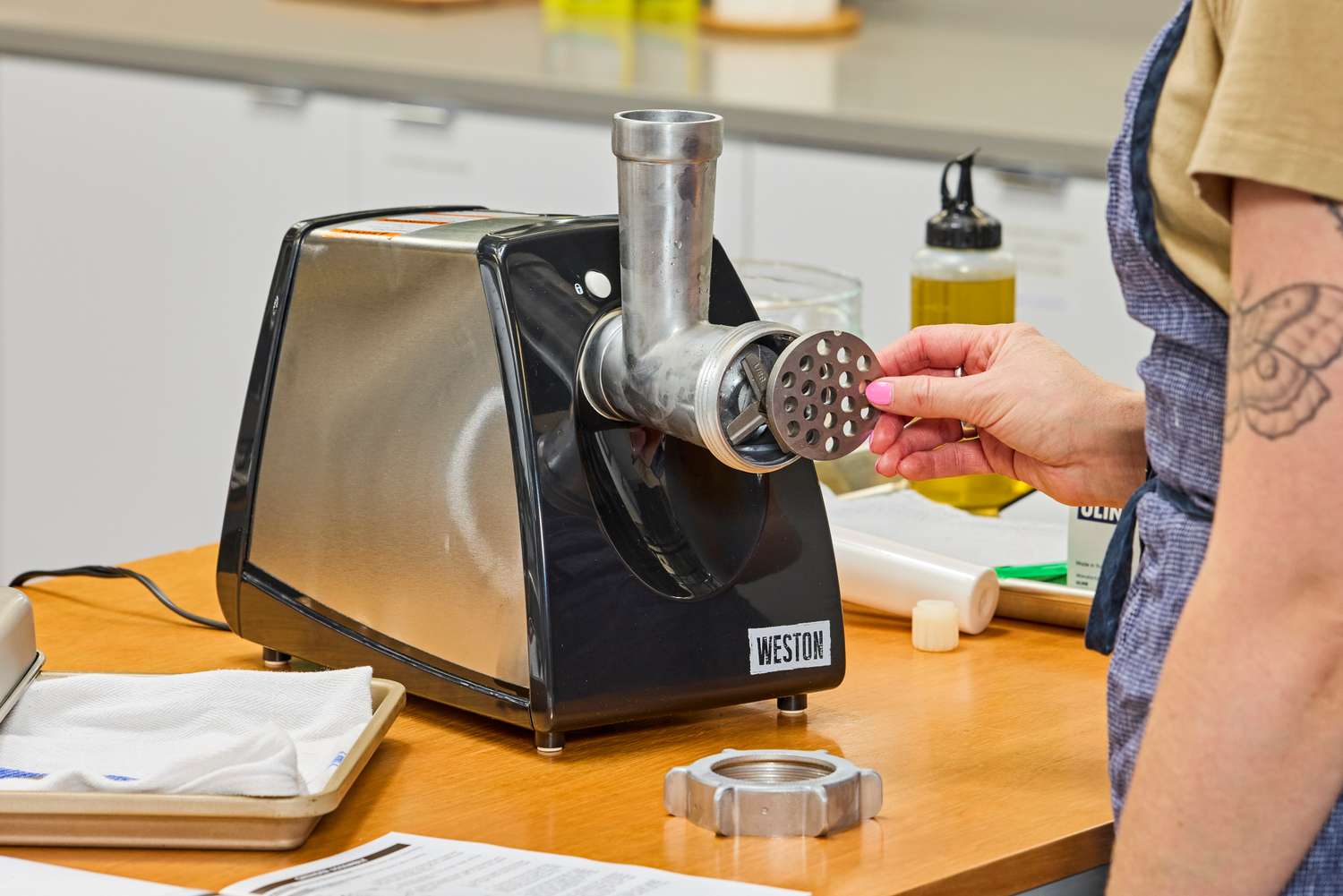 Person placing grinding plate to Weston #8 Electric Meat Grinder