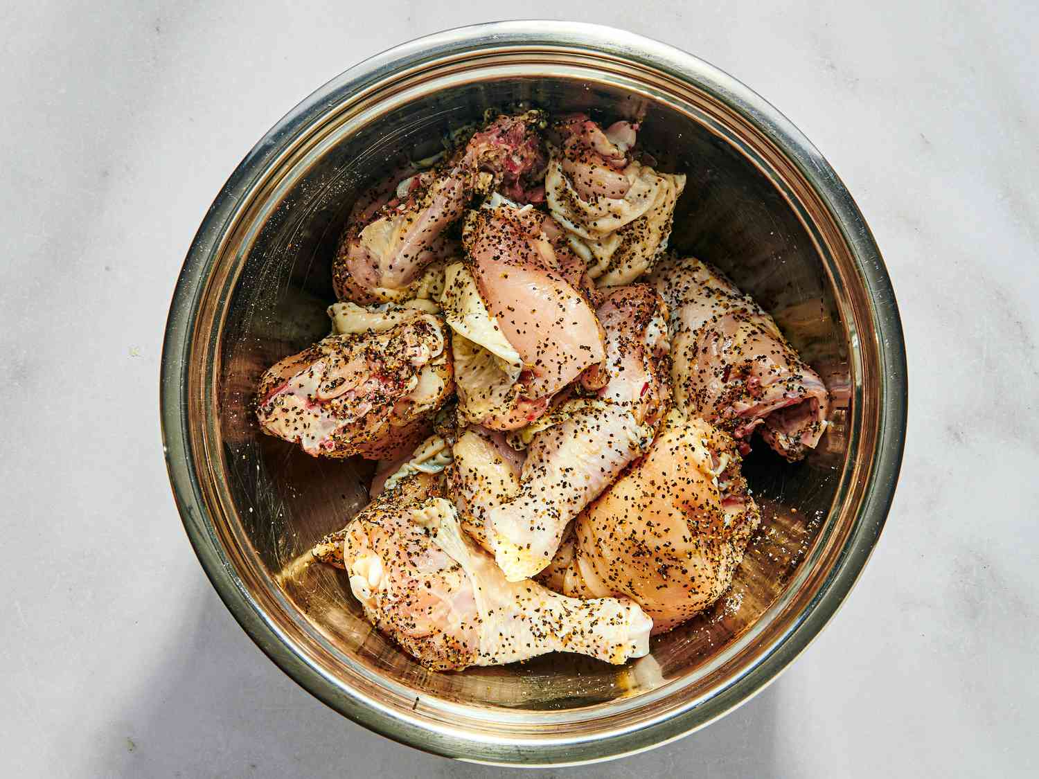 Raw chicken in a saucepan seasoned with salt and pepper 