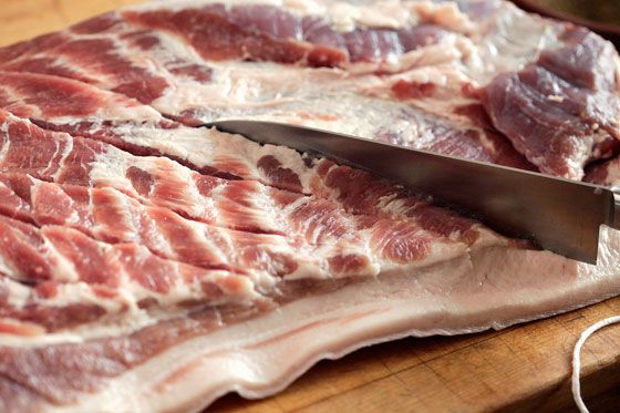 Scoring pork belly for porchetta with chef's knife