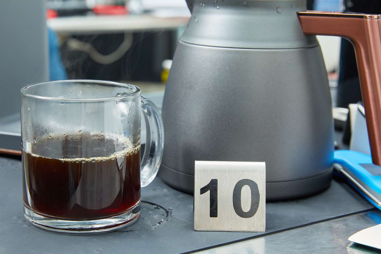 Coffee in a glass mug beside a thermal carafe