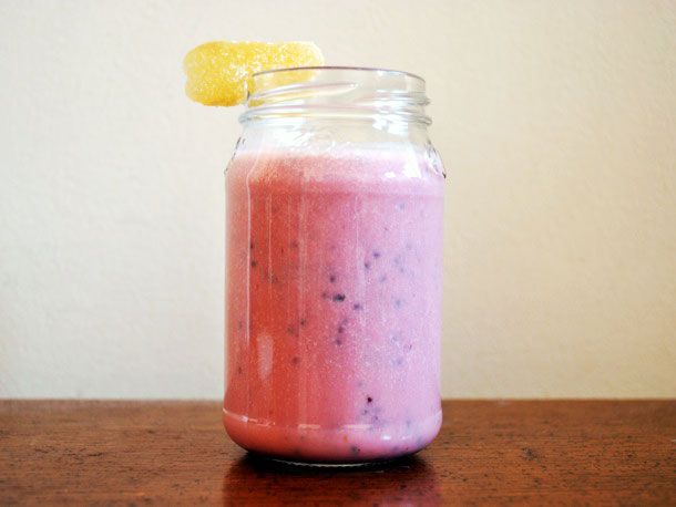 Profile view of a Light and Frothy Raspberry Faluda, served in a pint jar with a candied ginger garnish.