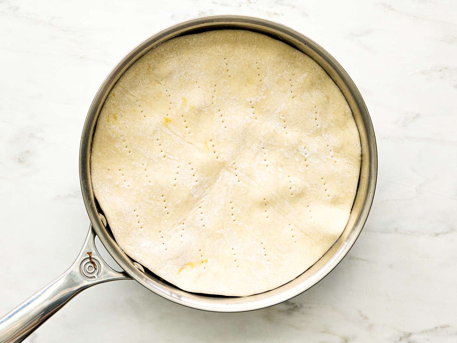 Puffed pastry covering filling in a skillet preparation for baking a Tarte Tatin dish