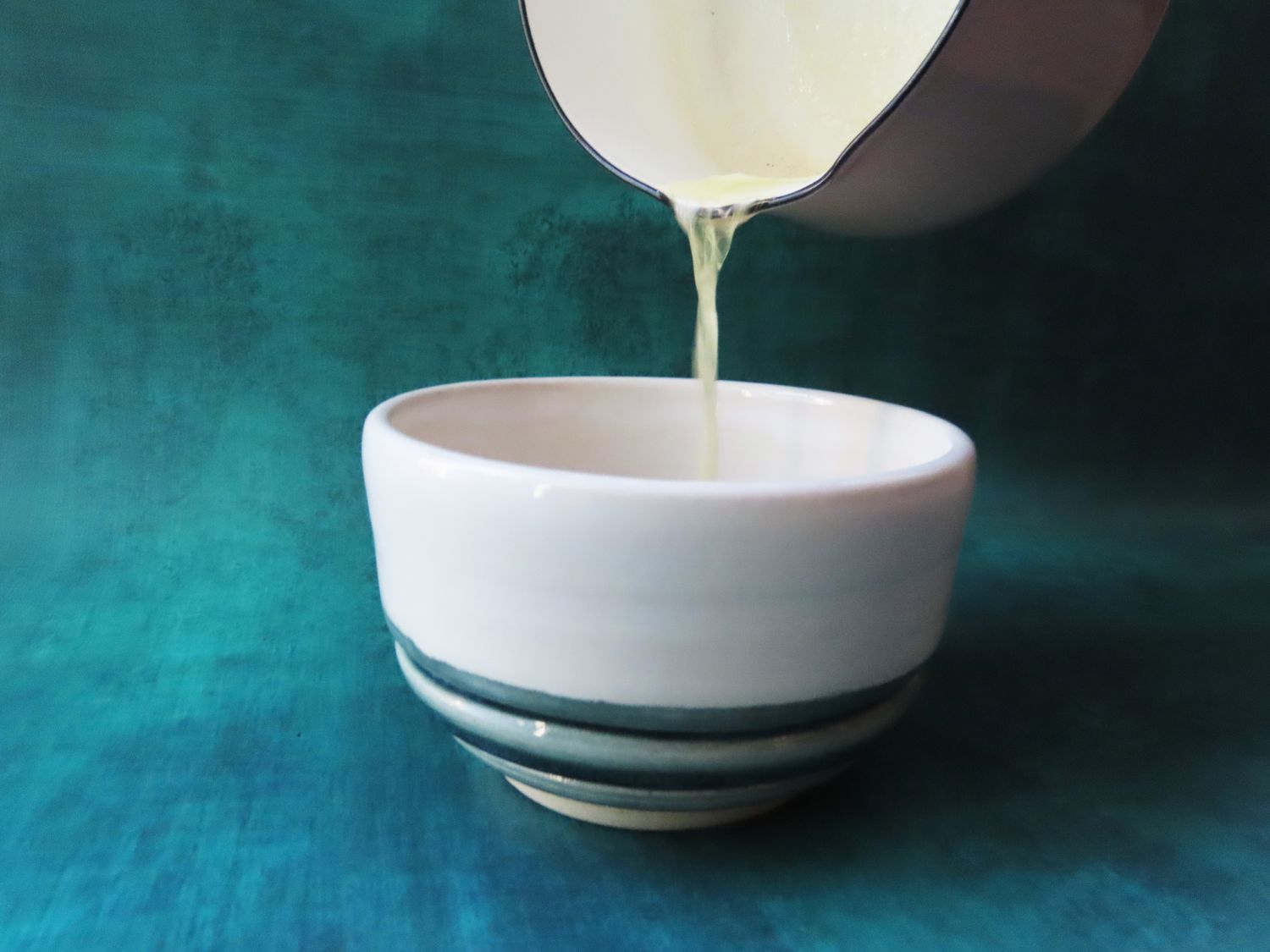 The Dansk butter warmer pouring butter into a small bowl