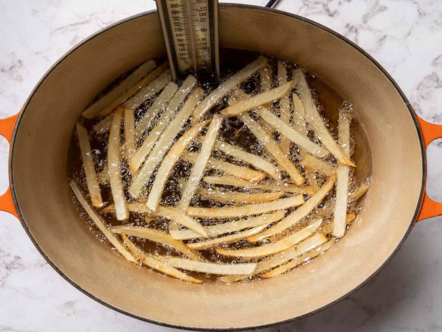 French fries frying in a large pot of oil