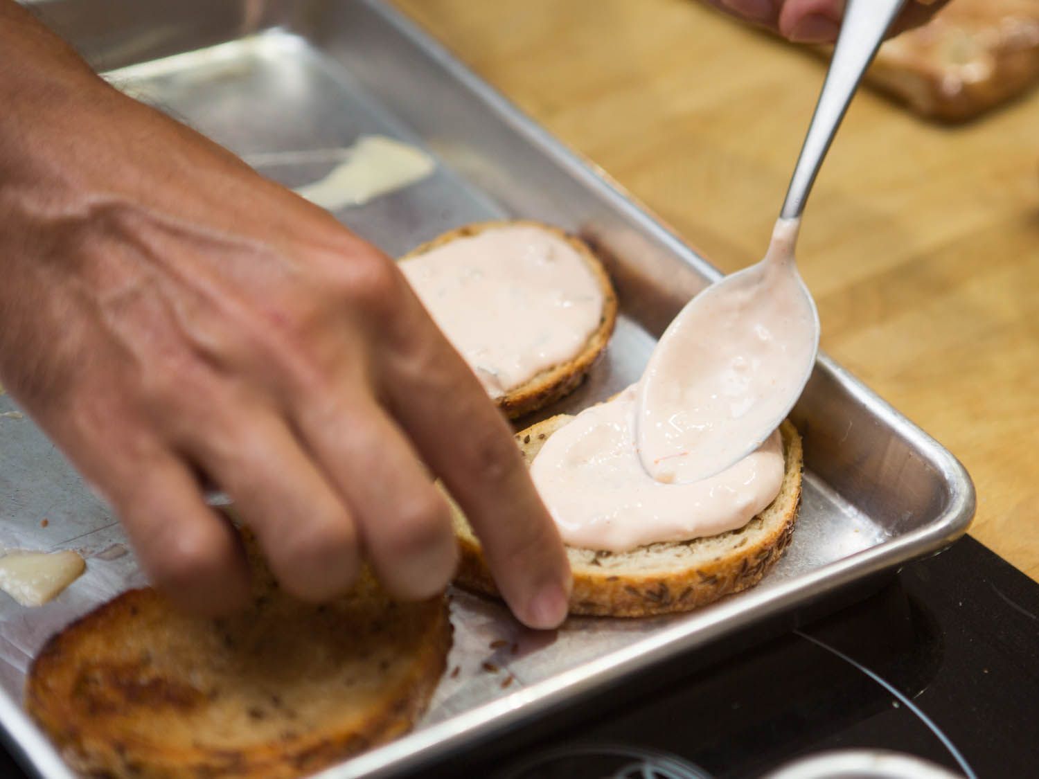 Russian dressing spread on bread for reuben burger