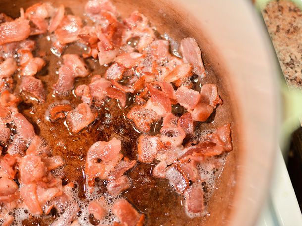 Chopped bacon rendering in a pot. 