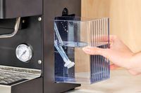 A person adjusting the water container of the Diletta Mio Espresso Machine