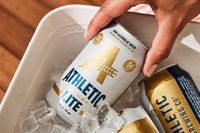 A hand pulling Athletic light beer out of a cooler