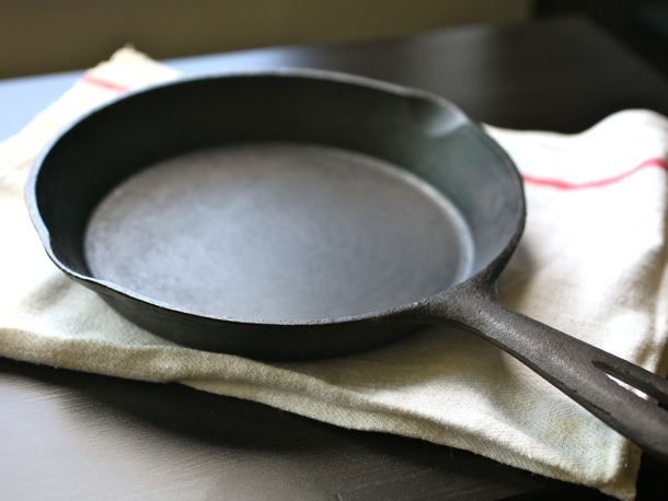 A cast iron skillet resting on a cloth on a table