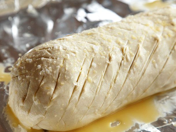 Fully wrapped beef Wellington brushed with egg wash, scored, and sprinkled with salt.