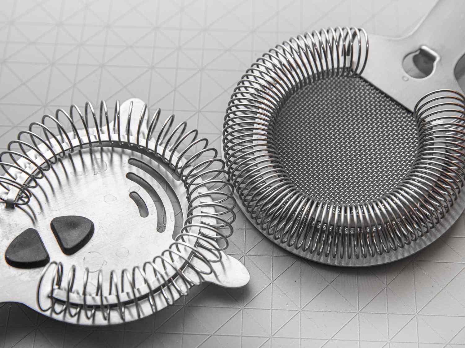 Two hawthorne strainers side-by-sideâone with a looser spring and the other with a tight spring