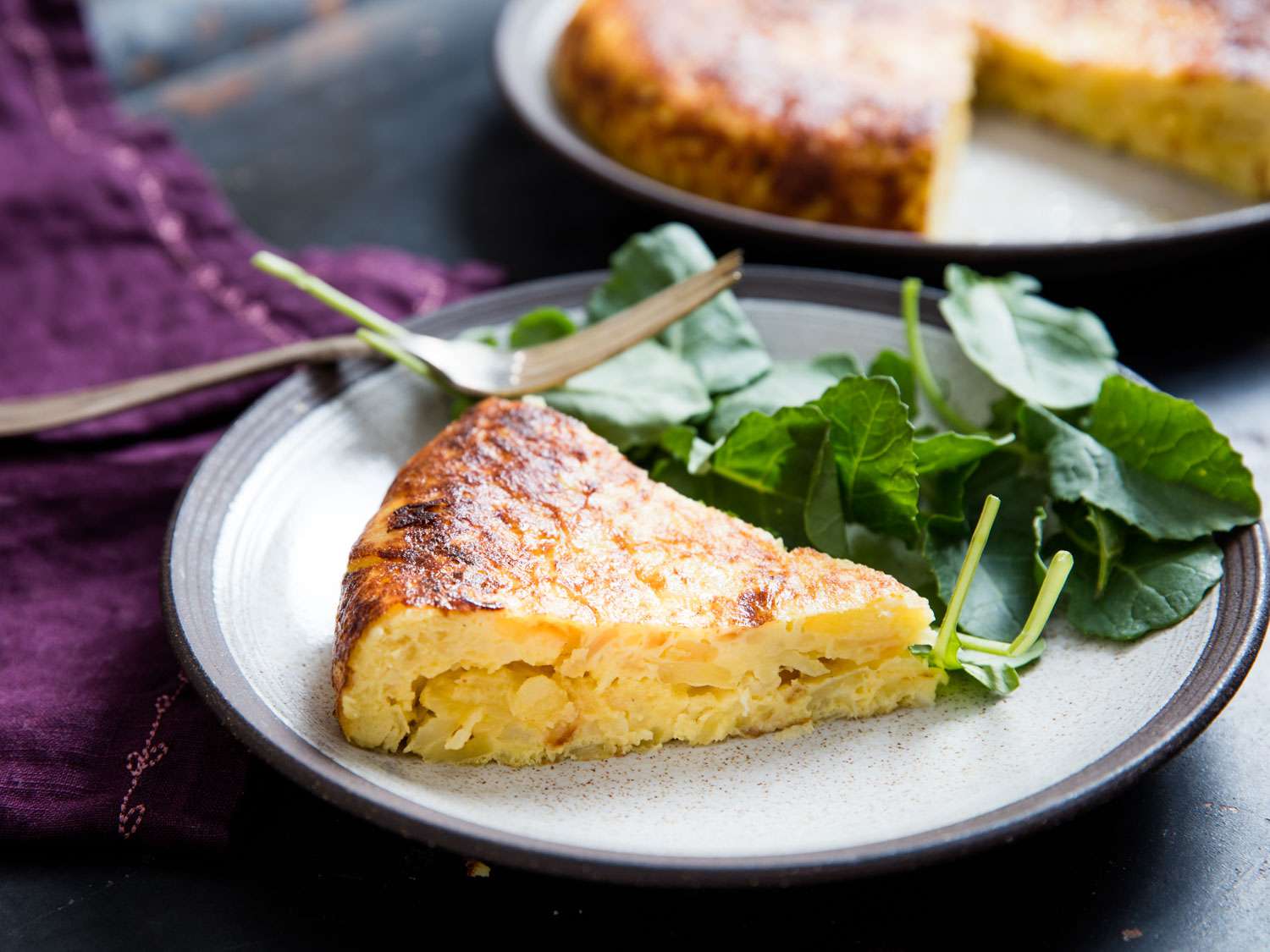 Spanish tortilla plated with greens