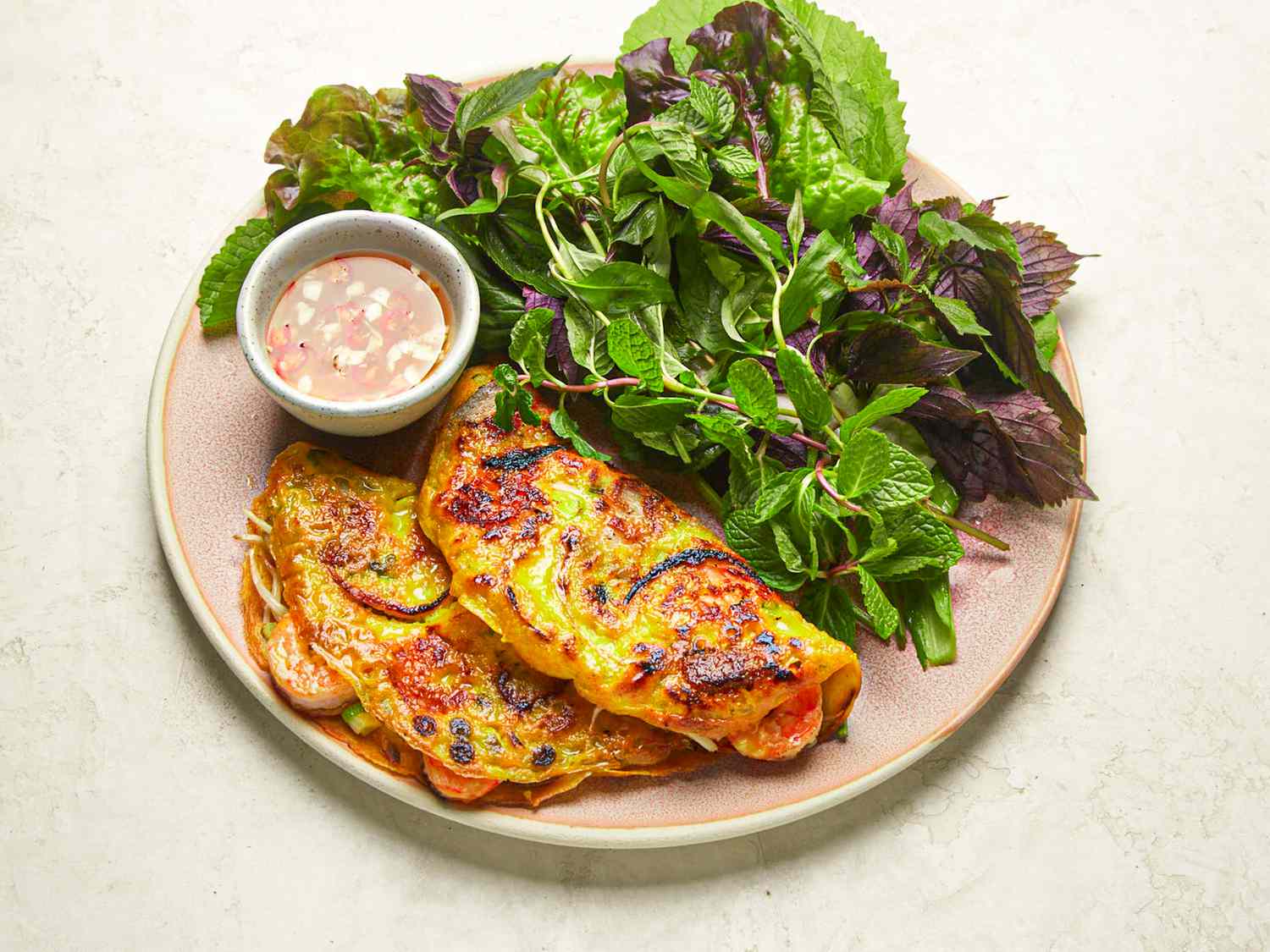 Side angle view of a plate of banh xeo
