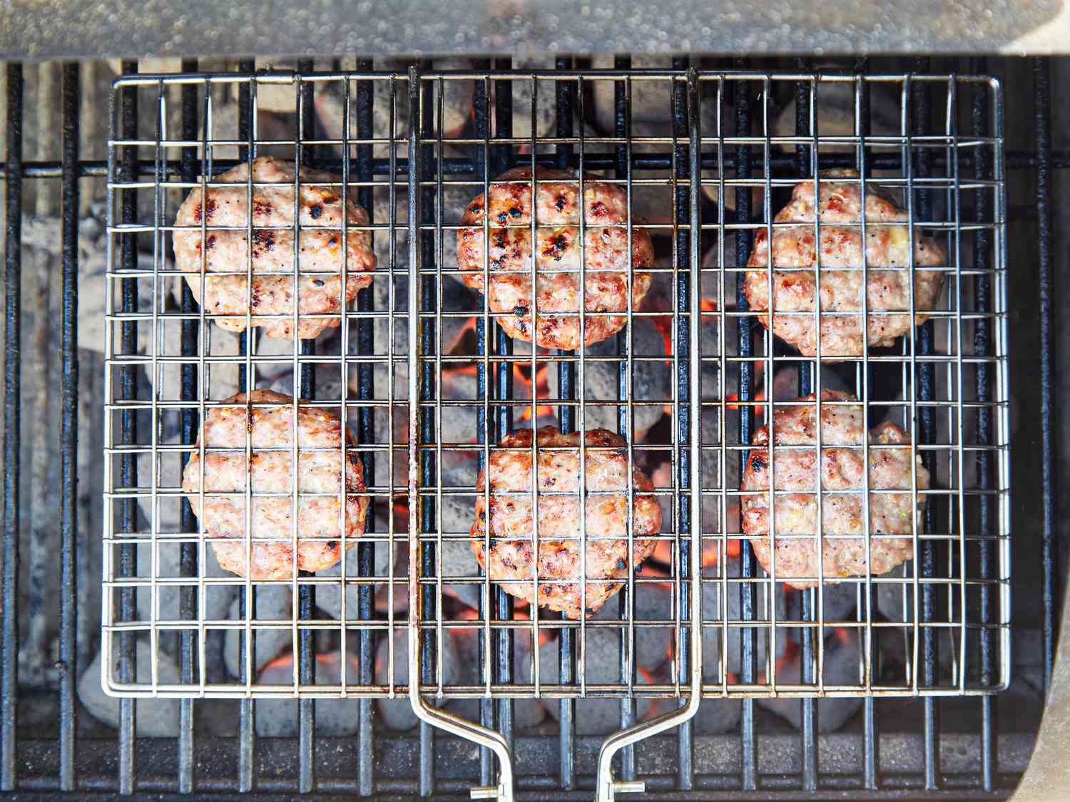 Overhead view of pork patties in a grilling basket