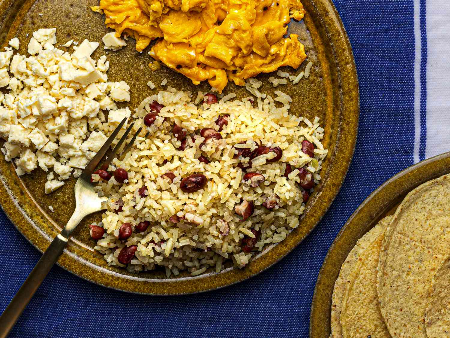 Gallopinto served with warm corn tortillas, scrambled eggs, and queso fresco on the side