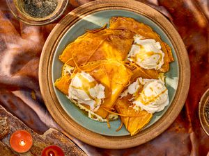 Plate of crepes topped with whipped cream and sauce