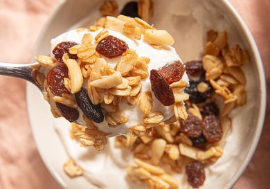 Overhead view a of spoon lifting up granola and yogurt