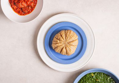 Overhead view of lafun, served with a greens soup and a bowl of obe ata (red pepper sauce).