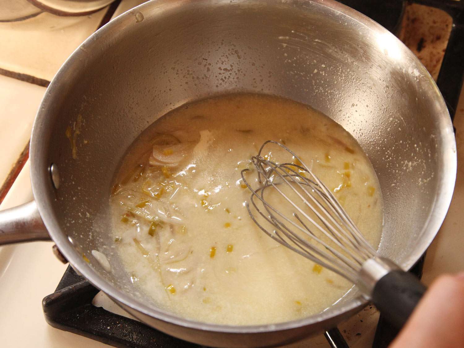 The aïoli is whisked into the cooking liquid.