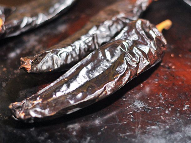 Guajillo chiles on a baking sheet for making red enchilada sauce.