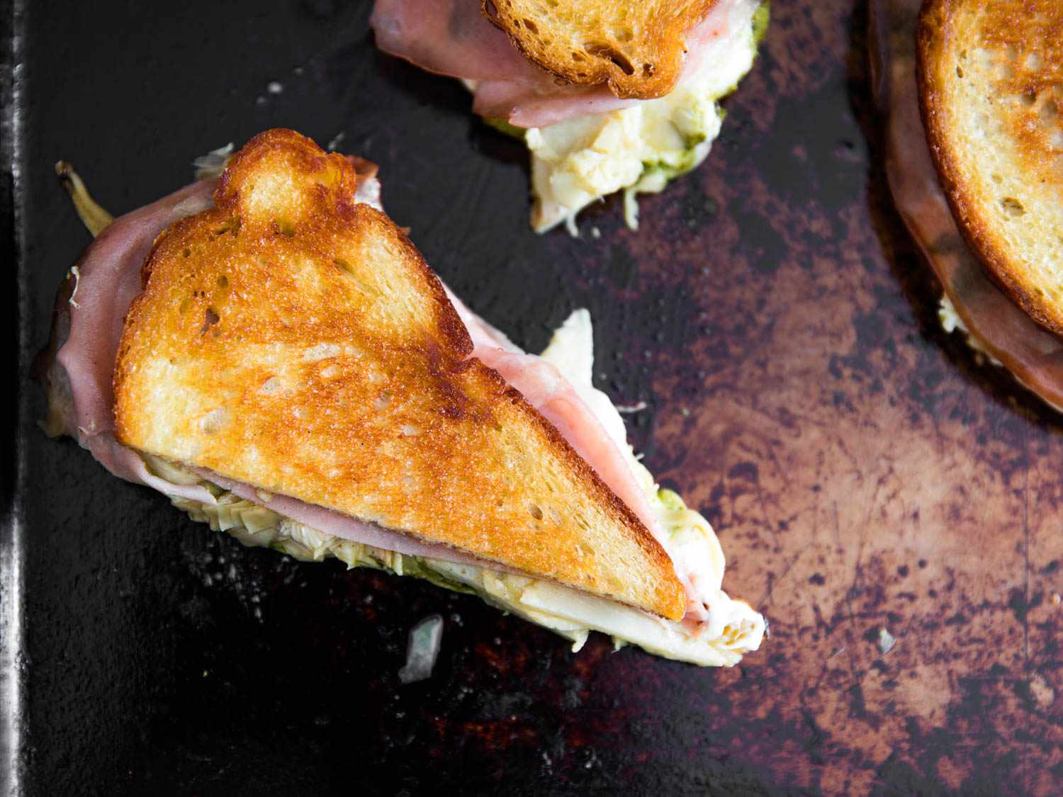 An overhead view of a mozzarella and mortadella grilled cheese on a skillet.